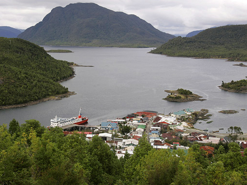 Paisaje con botes, cerros y mar de Puerto Aguirre